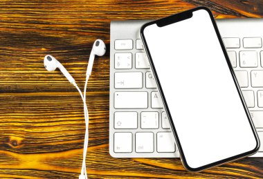 Smartphone ile boş perde kadar sahte. Smartphone izole ekran. Bilgisayar klavye üzerinde kopya alanı ile cep telefonu beyaz ekran. Metin için boş yer. İzole beyaz ekran