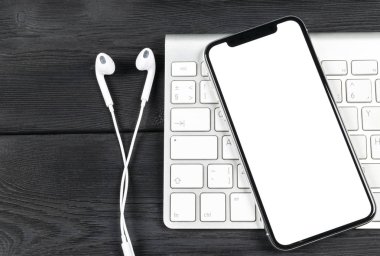 Smartphone ile boş perde kadar sahte. Smartphone izole ekran. Bilgisayar klavye üzerinde kopya alanı ile cep telefonu beyaz ekran. Metin için boş yer. İzole beyaz ekran
