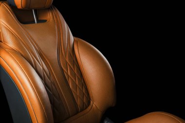 Kahverengi deri iç lüks modern araba. Turuncu deri rahat koltuklar siyah arka plan üzerine izole dikiş ile delikli. Modern araba iç ayrıntılar. Araba ayrıntılı. Arabanın içine