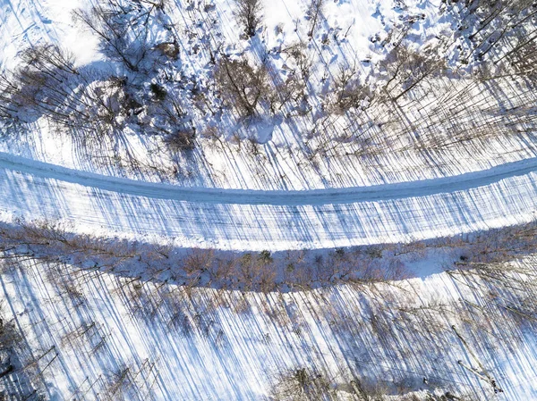 Veduta aerea di una strada invernale nella foresta. Paesaggio invernale cou — Foto Stock