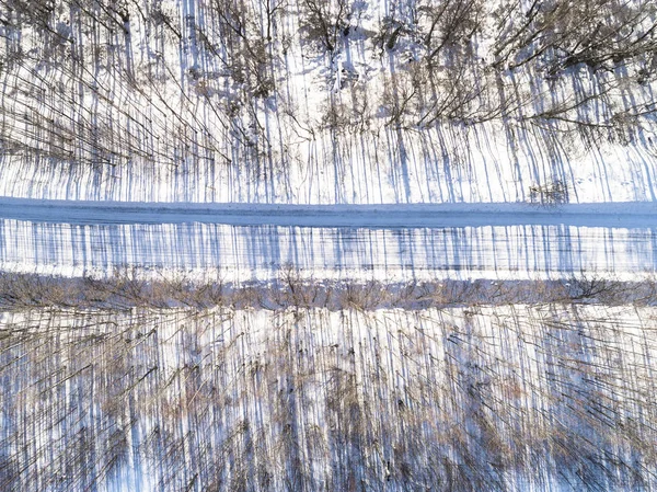 Vista aérea de uma estrada de inverno na floresta. Inverno paisagem cou — Fotografia de Stock