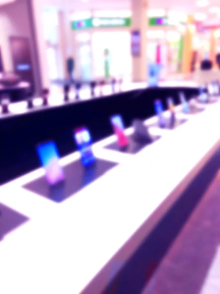 Abstract blur background with mobile store boutique in shopping mall. Electronic department store interior with bokeh light blurred background. Defocused blur background.  Blurry interior view retail shop — Stock Photo, Image