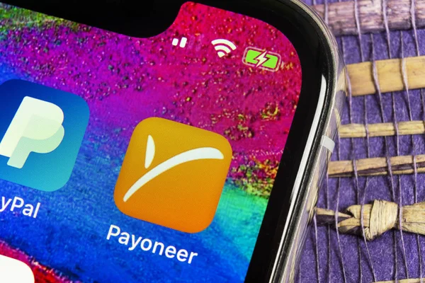 Icono de aplicación Payoneer en el primer plano de la pantalla del teléfono inteligente Apple iPhone X. Payoneer icono de la aplicación. Payoneer es un sistema de pago de finanzas electrónicas en línea — Foto de Stock