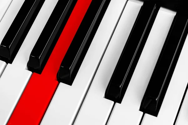 Top view of piano keys with one red button. Close-up of piano keys. Close frontal view. Piano keyboard with selective focus. Diagonal view. Piano keyboard perspective.