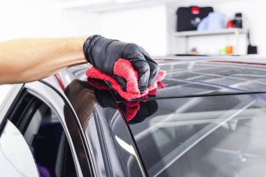 Mikrofiber bezle araba temizlik bir adam. Araba ayrıntılı veya kavram valeting. Seçici odak. Araba ayrıntılı. Süngerle Temizleme. Temizlik işçisi. Oto yıkama kavramı çözüm temizlemek için
