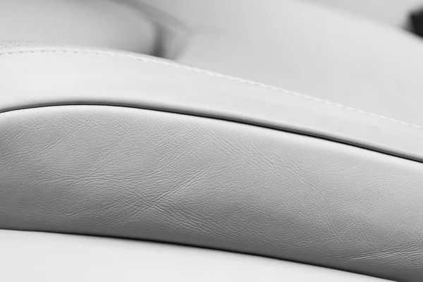 Белый кожаный интерьер роскошного современного автомобиля. Перфорированная белая кожа удобных сидений со стежкой. Современные детали интерьера автомобиля. Детализирую машину. Машина внутри — стоковое фото