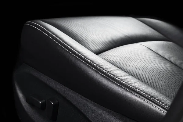 Modern Luxury car inside. Interior of prestige modern car. Comfortable leather seats. Perforated leather with stitching isolated on black background. Modern car interior. Car detailing. Car inside