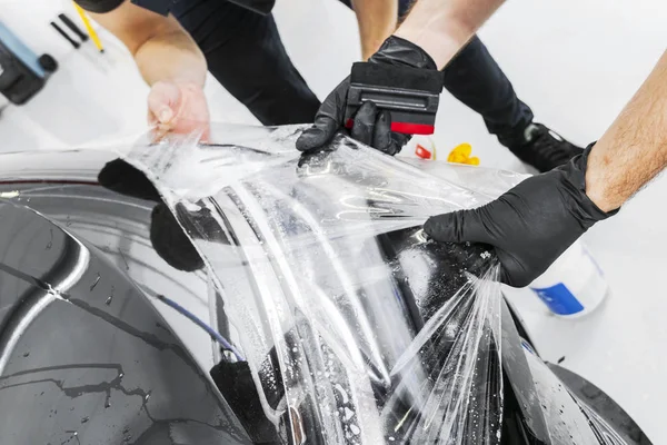 Araba kaydırma uzman vinil folyo ya da film araba koyarak. Koruyucu film araba. Koruyucu film araçları ile araba uygulamak. Araba ayrıntılı. Şeffaf film. Araç boya koruma. Kırpma