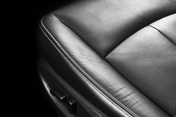 Modern Luxury car inside. Interior of prestige modern car. Comfortable leather seats. Perforated leather with stitching isolated on black background. Modern car interior. Car detailing. Car inside