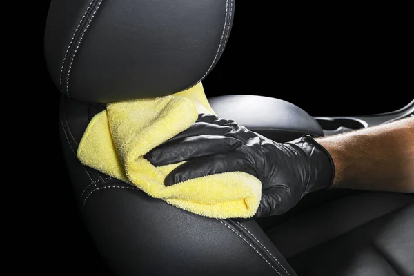 A man cleaning car seat with yellow microfiber cloth. Car detailing or valeting concept. Selective focus. Car detailing. Cleaning with sponge. Worker cleaning. Car wash concept solution to clean