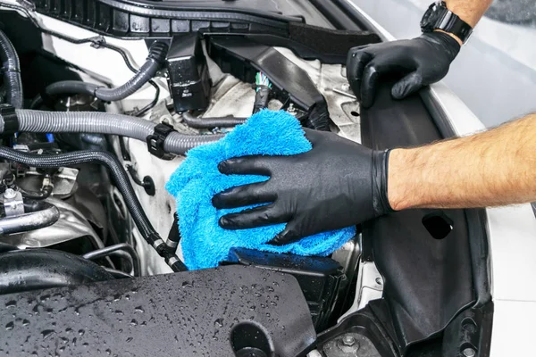 A man cleaning car engine with microfiber cloth. Car detailing or valeting concept. Selective focus. Car detailing. Cleaning with sponge. Worker cleaning. Car wash concept solution to clean — Stock Photo, Image