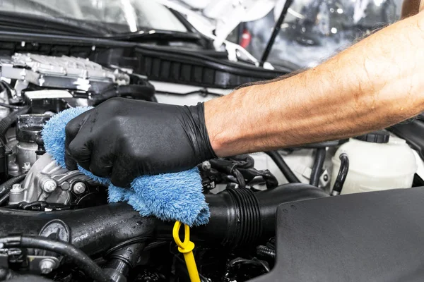 A man cleaning car engine with microfiber cloth. Car detailing or valeting concept. Selective focus. Car detailing. Cleaning with sponge. Worker cleaning. Car wash concept solution to clean — Stock Photo, Image