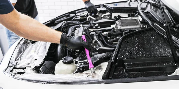 A man cleaning car engine with shampoo and brush. Car detailing or valeting concept. Selective focus. Car detailing. Cleaning with sponge. Worker cleaning. Car wash concept solution to clean — Stock Photo, Image