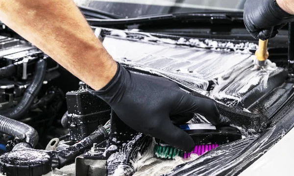 A man cleaning car engine with shampoo and brush. Car detailing or valeting concept. Selective focus. Car detailing. Cleaning with sponge. Worker cleaning. Car wash concept solution to clean — Stock Photo, Image
