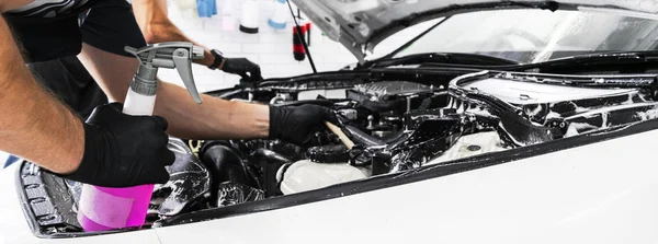 A man cleaning car engine with shampoo and brush. Car detailing or valeting concept. Selective focus. Car detailing. Cleaning with sponge. Worker cleaning. Car wash concept solution to clean — Stock Photo, Image