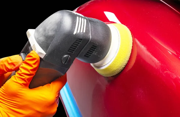 El coche pule las manos del trabajador de cera aplicando cinta protectora antes de pulir. Coches de pulir y pulir. Detallando el coche. El hombre sostiene un pulidor en la mano y pule el coche — Foto de Stock