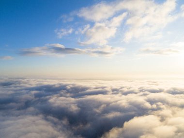 Mavi gökyüzünde havadan görünümü beyaz bulutlar. Üstten görünüm. Drone görüntüleyin. Hava kuş bakışı. Hava üstten görünüm cennet. Bulutlar doku. Yukarıdan görüntüleyin. Gündoğumu veya günbatımı bulutlar üzerinde
