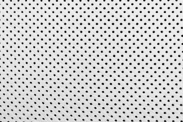 Modern luxury Car white leather interior.  Part of perforated leather car seat details. White Perforated leather texture background. Texture, artificial leather with stitching. Comfortable perforated leather seats