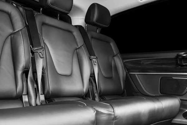 Задние пассажирские сиденья в современном роскошном автомобиле. Фронтальный вид. Перфорированная кожа с белым стежком. Детализирую машину. Кожаные кресла. Детали салона автомобиля. Черное и белое — стоковое фото