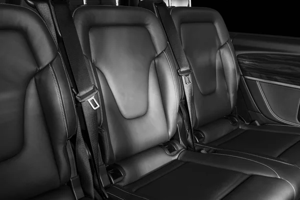 Back passenger seats in modern luxury car. Frontal view. Perforated leather with white stitching. Car detailing. Back Leather comfortable seats. Car interior details. Black and white — Stock Photo, Image