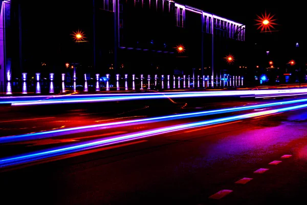 Cars light trails on a curved highway at night. Night traffic trails. Motion blur. Night city road with traffic headlight motion. Cityscape. Light up road by vehicle motion blur.
