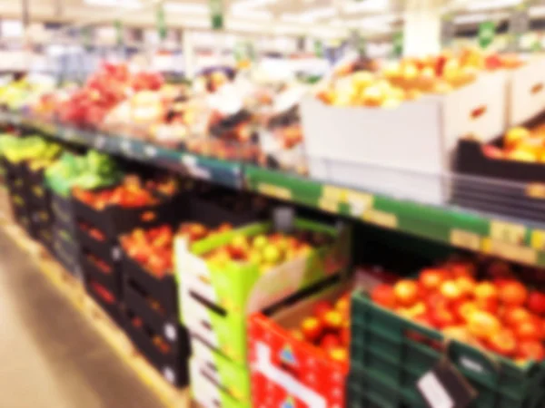 Blurred fresh fruits and vegetables at retail store. Abstract background of supermarket. Grocery market blurred background. Fruits in store racks. Interior shopping mall defocused background — Stock Photo, Image
