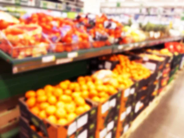 Verschwommenes frisches Obst und Gemüse im Einzelhandel. Abstrakter Hintergrund des Supermarktes. Lebensmittelmarkt verschwimmt Hintergrund. Früchte in den Regalen. Innenraum Shopping Mall defokussiert Hintergrund — Stockfoto