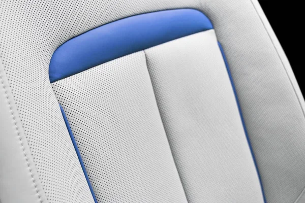 White leather interior of the luxury modern car. Perforated white leather comfortable seats with stitching. Modern car interior details. Car detailing. Car inside. Leather texture background