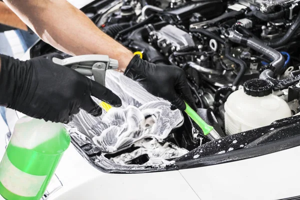 Cars in a carwash. Car wash with foam at station. Carwash. Washing at the station. Car washing concept. Car detailing. A man cleaning car. Cleaning engine with the foam and a brush — Stock Photo, Image