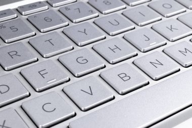 Modern gümüş dizüstü bilgisayar klavyesinin yakın çekim. Dizüstü bilgisayar klavyesi. Yeni ve ergonomik bilgisayar klavyesinin ayrıntıları. 
