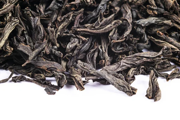 Macro shot of a high quality black tea. Black tea background close up. Leaf closeup. Background of dried tea leaves of dark color. Macro photo. Pile of black tea leaves. — Stock Photo, Image