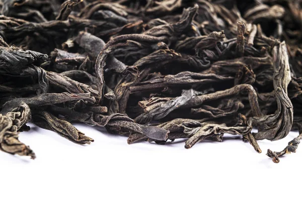 Macro shot of a high quality black tea. Black tea background close up. Leaf closeup. Background of dried tea leaves of dark color. Macro photo. Pile of black tea leaves. — Stock Photo, Image