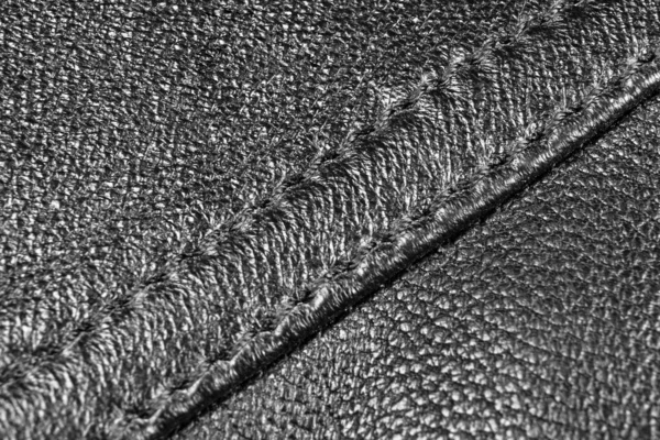 Black perforated leather texture background. Black Leather with stitching close up. Macro shot of shiny leather texture. Texture background — Stock Photo, Image