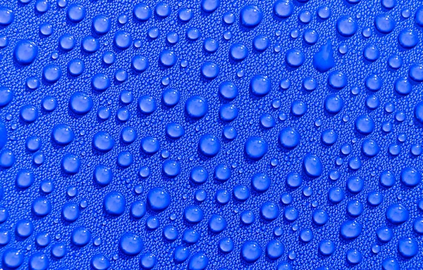 Gotas de agua transparente sobre fondo azul claro. Gotas de agua azul. Gotas de lluvia sobre vidrio. Fondo abstracto azul gota de agua. Superficie del agua — Foto de Stock