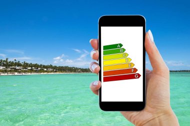 Ev verimliliği derecelendirmesi ile el tutma dijital akıllı telefon. Dijital tablet ekranında ev verimliliği derecelendirmesinin ayrıntıları. Ekolojik ve biyo enerjik ev kavramı. Enerji sınıfı.