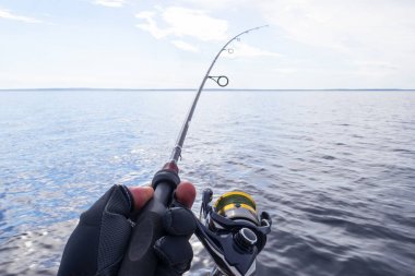 Gölde balık tutma. Balıkçı olta ile elleri. Makro vurdu. Olta ve balıkçı Gölü su üzerinde elinde. İplik çubuk. Olta takımı