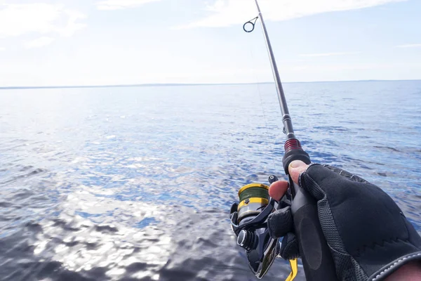 Fishing on the lake. Hands of fisherman with fishing rod. Macro shot. Fishing rod and hands of fisherman over lake water. Spinning rod. Fishing tackle — Stock Photo, Image