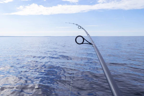 Angelruten-Spinnring mit der Schnur in Großaufnahme. Angelrute über dem kristallklaren Wasser. Angelrutenringe. Angeln. Fischerspinnrolle. weiche Beleuchtung — Stockfoto