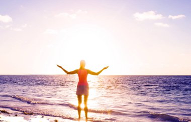 Kız siluet plaj gün batımı ayakta arıyorum. Okyanusu günbatımı. Tropikal plaj. Seyahat kavramı. Batımını kız. Model kız siluet günbatımı gökyüzü üzerinde. Yüzme ve yaz sahilde günbatımı üzerinde sıçramasına.