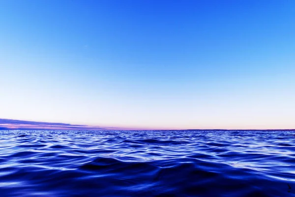 Επιφάνεια νερού. Άποψη ενός φόντου ηλιοβασιλέματος ουρανού. Δραματικό χρυσό ηλιοβασίλεμα ουρανό με σύννεφα ουρανό βράδυ πάνω από τη θάλασσα. Άποψη μιας κρυστάλλινης υφής θαλασσινού νερού. Τοπίο. Μικρά κύματα. Αντανάκλαση νερού — Φωτογραφία Αρχείου