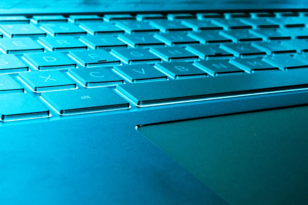 Modern gümüş dizüstü bilgisayar klavyesinin yakın çekim. Dizüstü bilgisayar klavyesi. Yeni ve ergonomik bilgisayar klavyesinin ayrıntıları. Mavi tonları — Stok fotoğraf