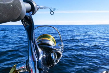 Olta hattı yakın çekim ile dönen. Balıkçılık gün nedeniyle balıkçı teknesinde çubuk tutucu olta. Olta halkaları. Olta takımı. Balıkçılık iplik makara. 