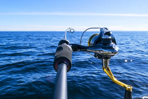 Fishing rod spinning with the line close-up. Fishing rod in rod holder in fishing boat due the fishery day. Fishing rod rings. Fishing tackle. Fishing spinning reel. — Stock Photo, Image