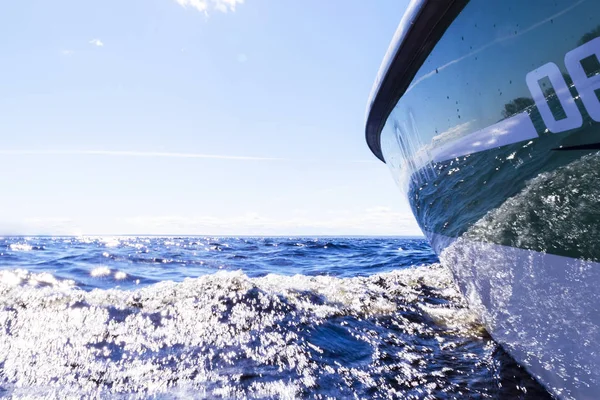 Vista lateral Velocidad barco de pesca a motor con gotas de agua. Océano azul reflexiones olas de agua de mar con yate de pesca rápida. Barco a motor en el océano azul. Yate oceánico. Puesta de sol en la cubierta del velero — Foto de Stock