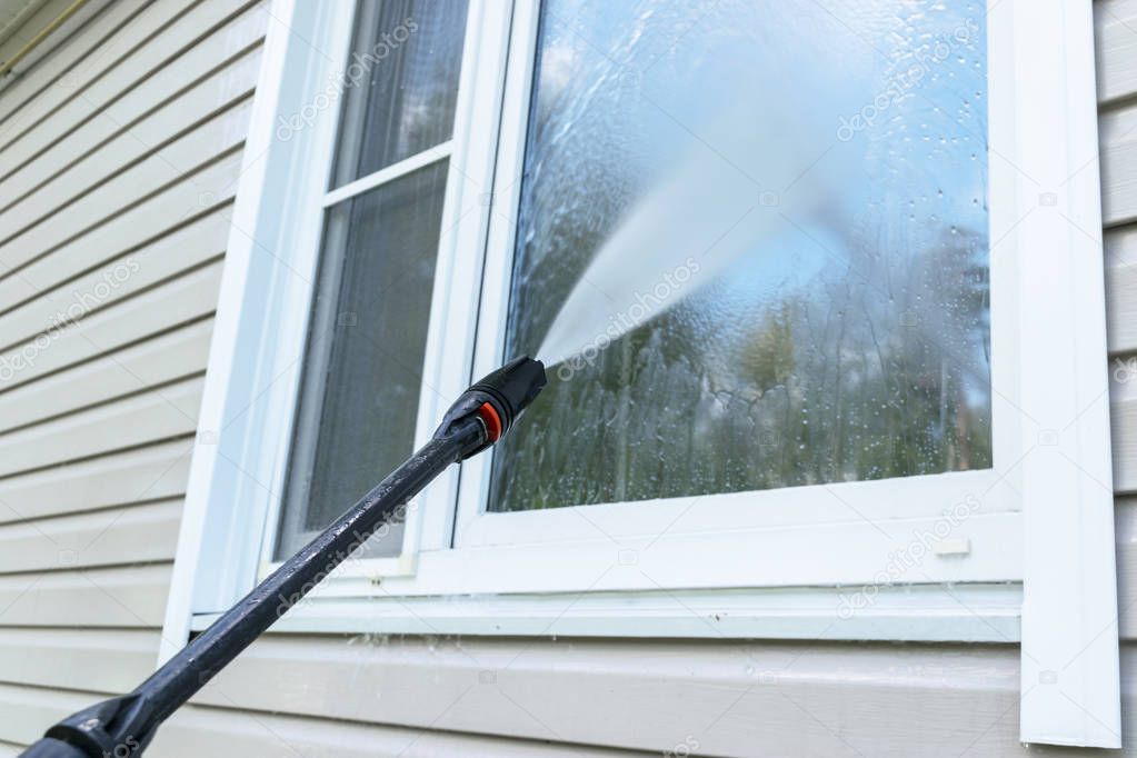 Cleaning service washing building facade and window with pressure water. Cleaning dirty wall with high pressure water jet. Power washing the wall. Cleaning the facade of the house. Before and after washing
