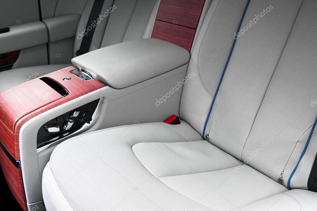 Back passenger seats in modern luxury car. Frontal view. White perforated leather with stitching. Car detailing. Leather comfortable white seats. Car interior details. Car inside