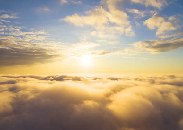 Aerial view White clouds in blue sky. Top view. View from drone. Aerial bird\'s eye view. Aerial top view cloudscape. Texture of clouds. View from above. Sunrise or sunset over clouds