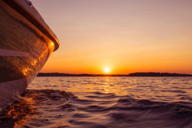 Bir damla suyla balıkçı teknesinin yan görüntüsü. Mavi okyanus suyu gün batımında yansıyor. Mavi okyanusta sürat teknesi. Okyanus yatı. Yelkenli güvertesinde gün batımı