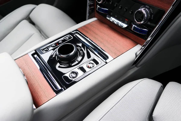 Modern luxury car white leather interior with natural wood panelModern luxury car white leather interior with natural wood panel. Part of leather car seat details with stitching. Interior of prestige modern car. White perforated leather. Car detailin