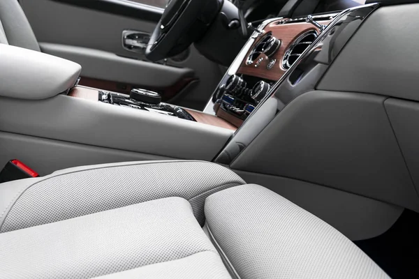 Modern luxury car white leather interior with natural wood panel. Part of leather car seat details with stitching. Interior of prestige modern car. White perforated leather. Car detailing. Car inside — Stock Photo, Image